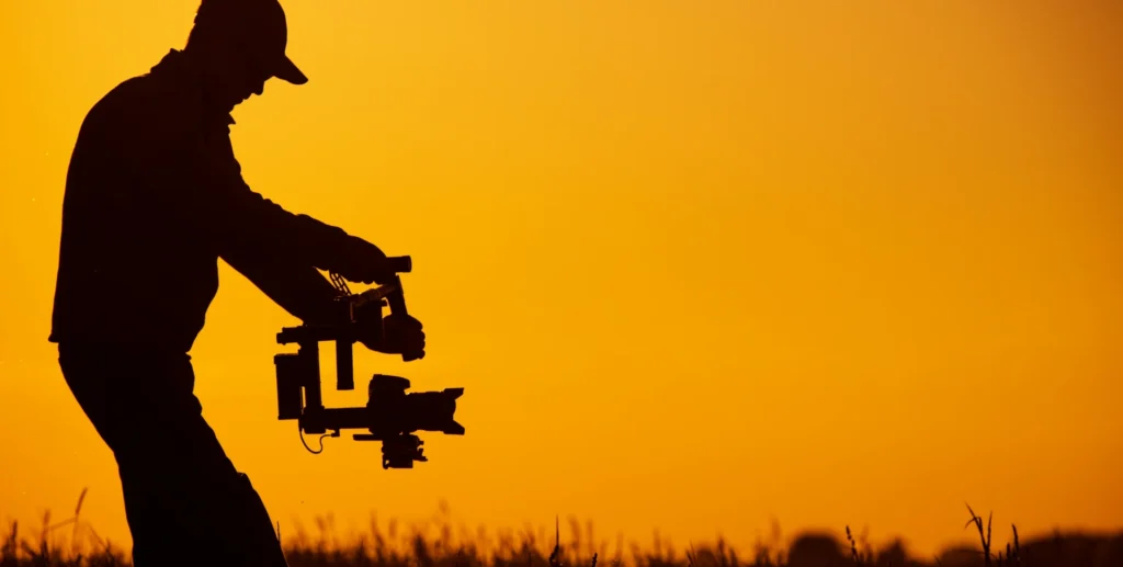 Opérateur caméra ABRID Films avec stabilisateur au coucher du soleil